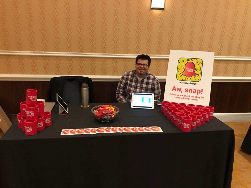 Matchbox Design Group's Booth At MDMC17 or the Midwest Digital Marketing Conference located in St. Louis, MO at Union Square Cullen sitting behind the table at the career fair during MDMC17 otherwise known as the Midwest Digital Marketing Conference.