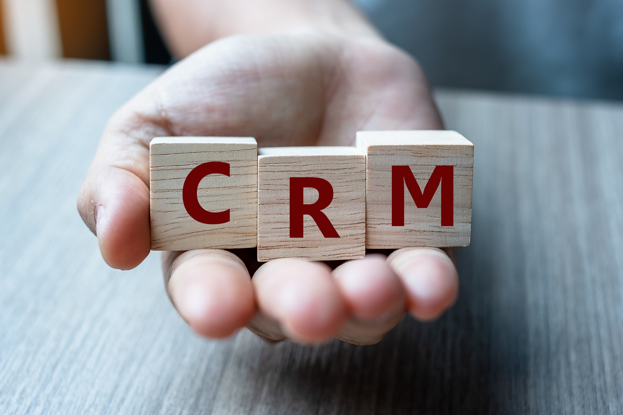 Have An Effective CRM | St. Louis Marketing Agency Business woman hand holding wooden cube with CRM text (Customer Relationship Management).