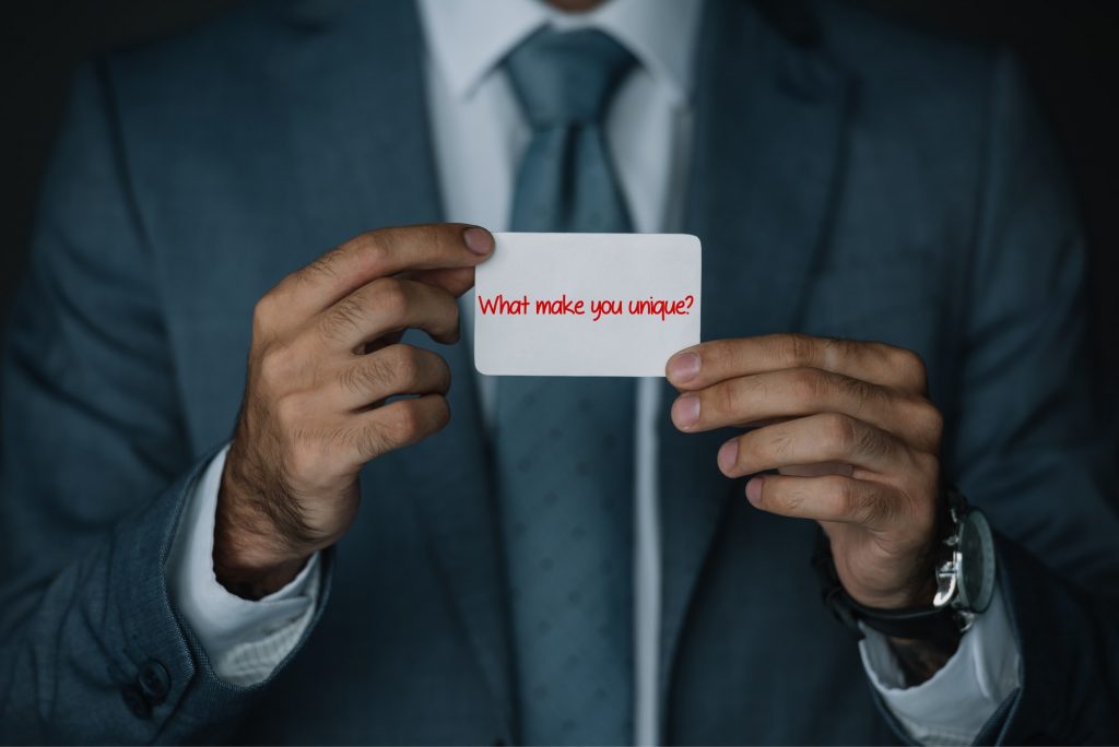 SEO Makes Your Company Unique | Matchbox Design Group | St. Louis, MO Man holding up card that says "what make you unique"?