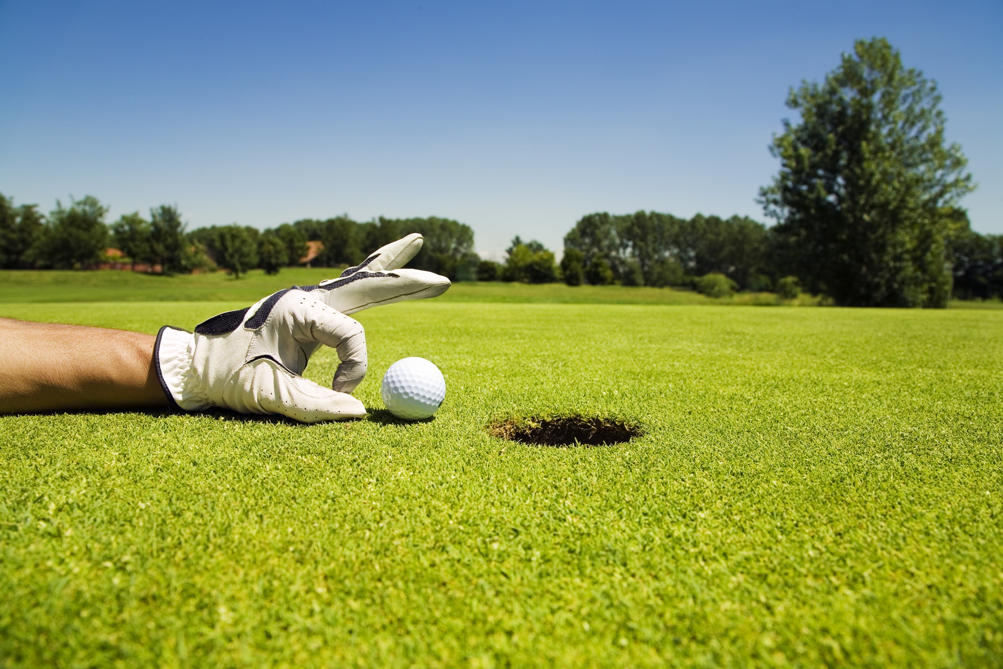 Golf Player Cheating Putting Ball Into Hole With Hand. This short-term gain will hurt him in the long run.