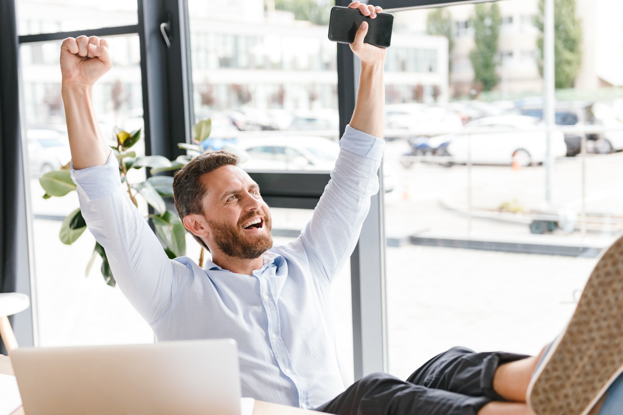 Happy cheerful bearded man in office. Keeping old customers happy.