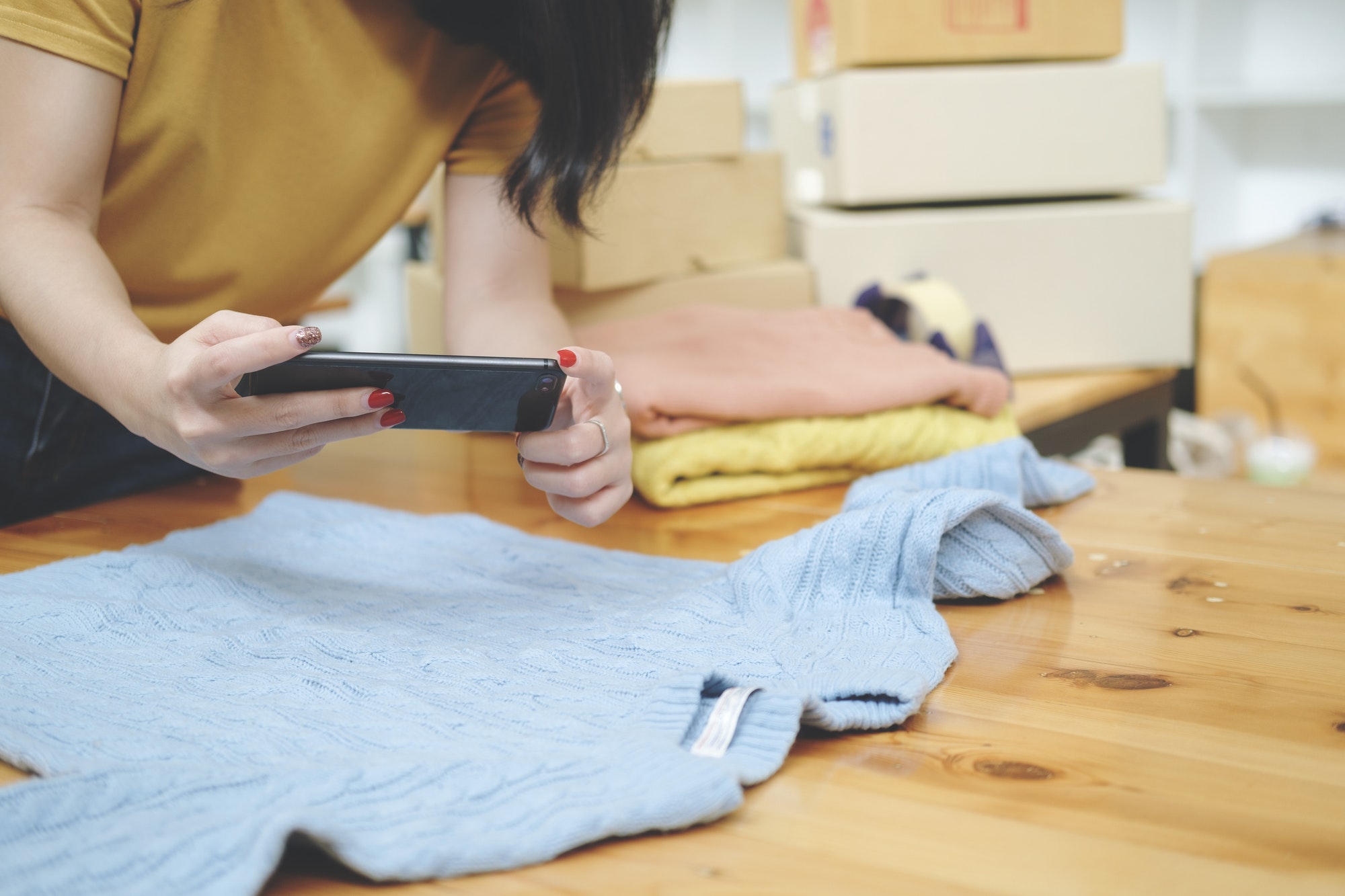Online seller owner take a photo of product for upload to website online shop.