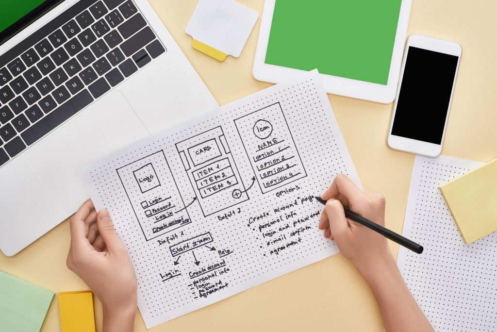 Top Web Design Errors That Will Cost You Conversions | Matchbox Design Group | St. Louis, MO Person sketching a web design project on paper to avoid the top web design errors that will cost you conversions.