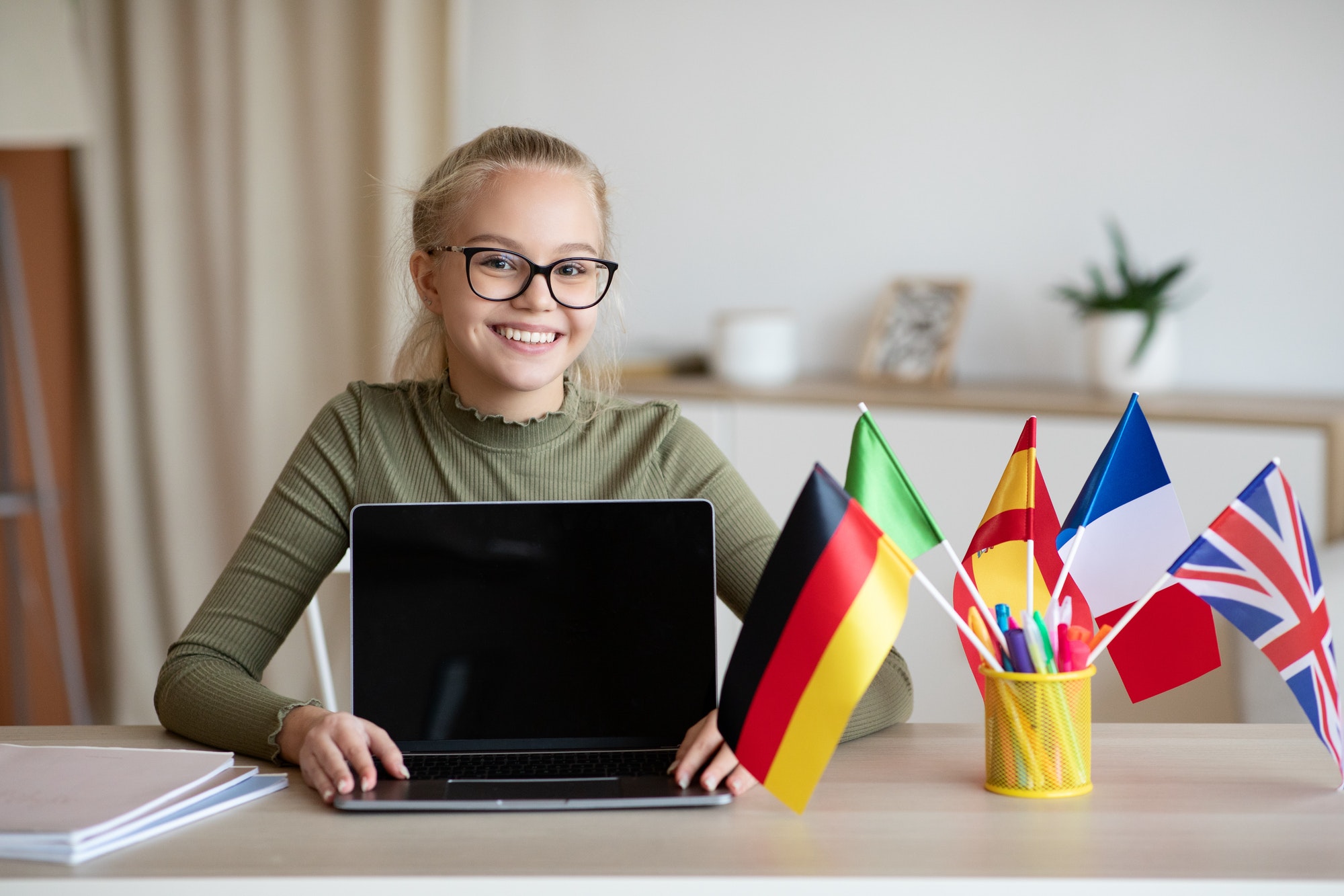 Girl with laptop showing many international flags.