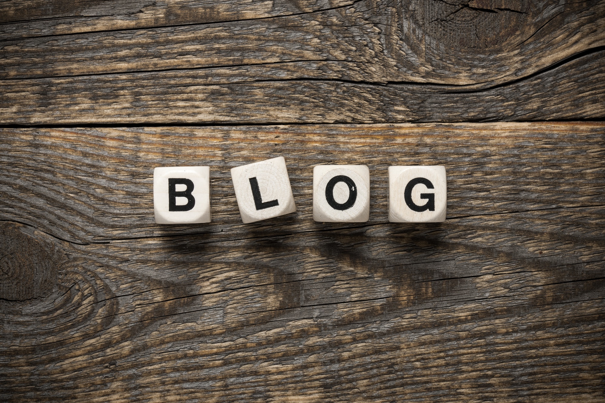 Blog written on dice with wooden background. A Beginners Guide To Building Your Blog Audience.