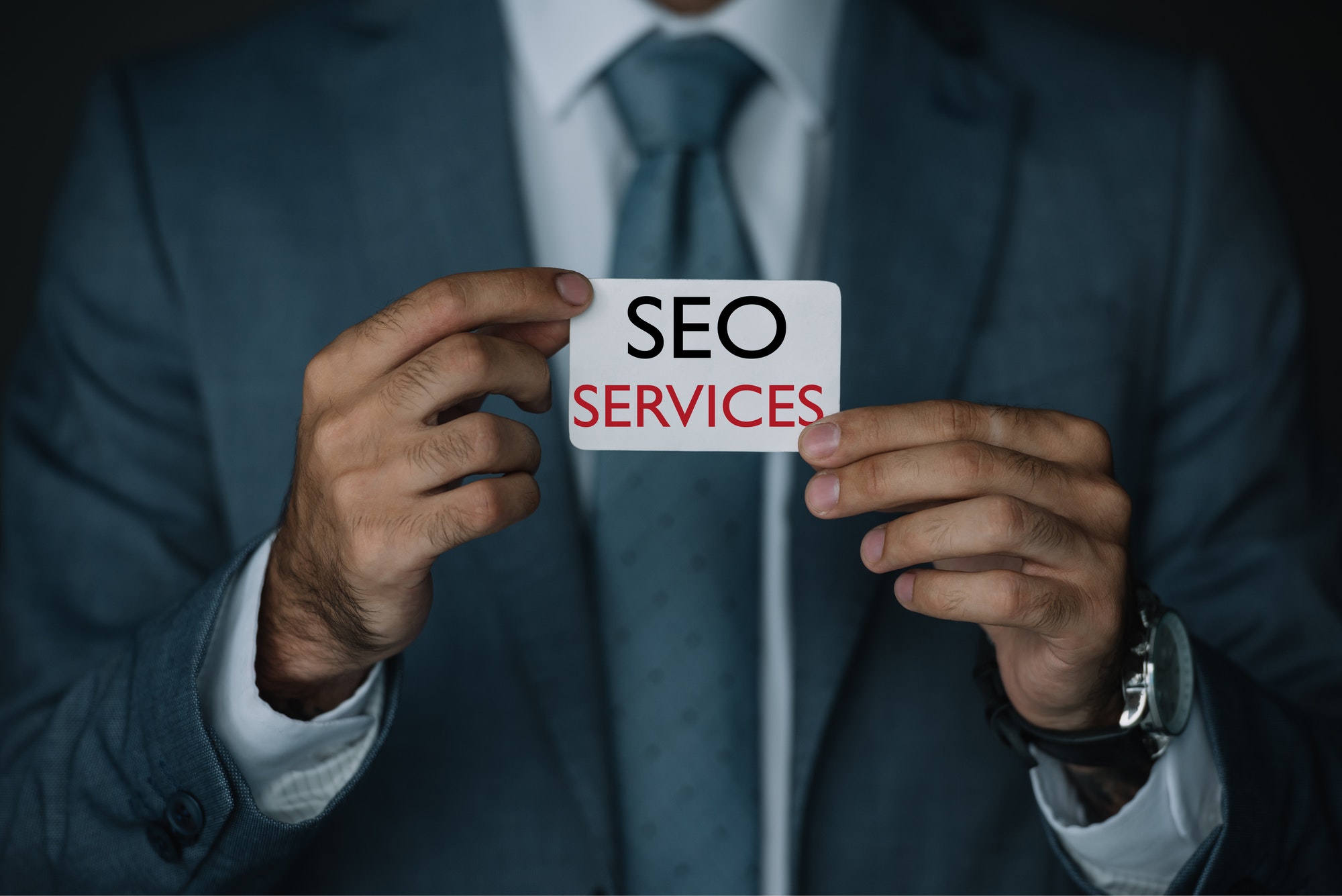 Man holding SEO Services sign. The Magnitude Of SEO Services.