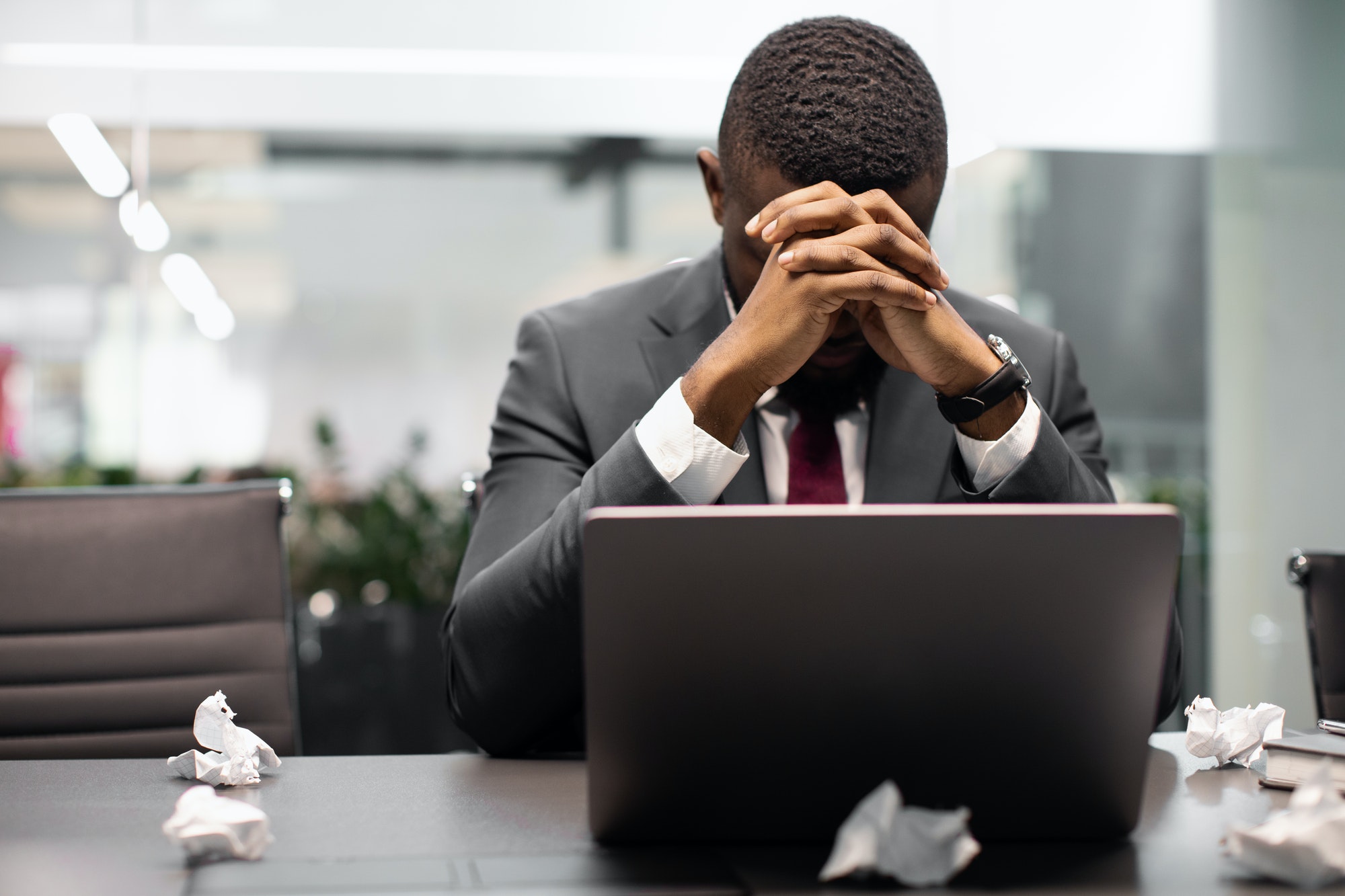 Tired manager suffering from burnout, working on laptop.