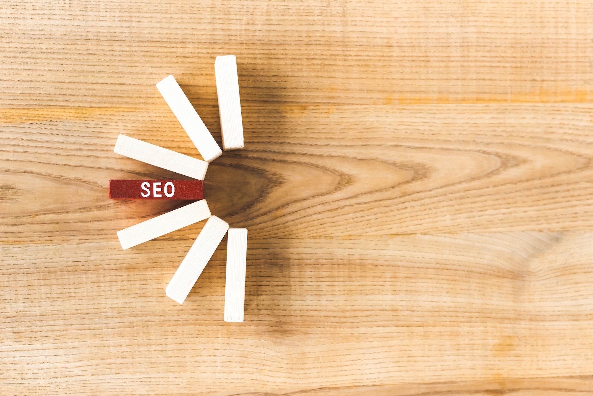 Top view of wooden rectangles with lettering SEO on table.