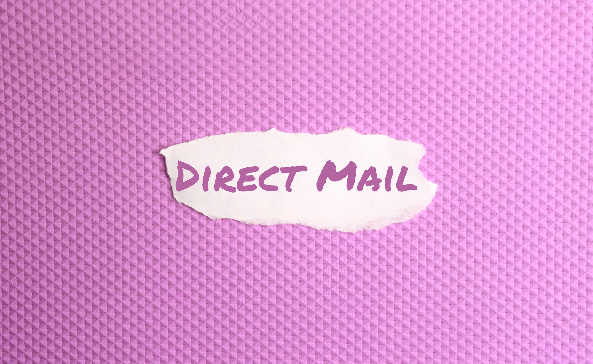 a torn paper written with inscription direct mail on a pink background.