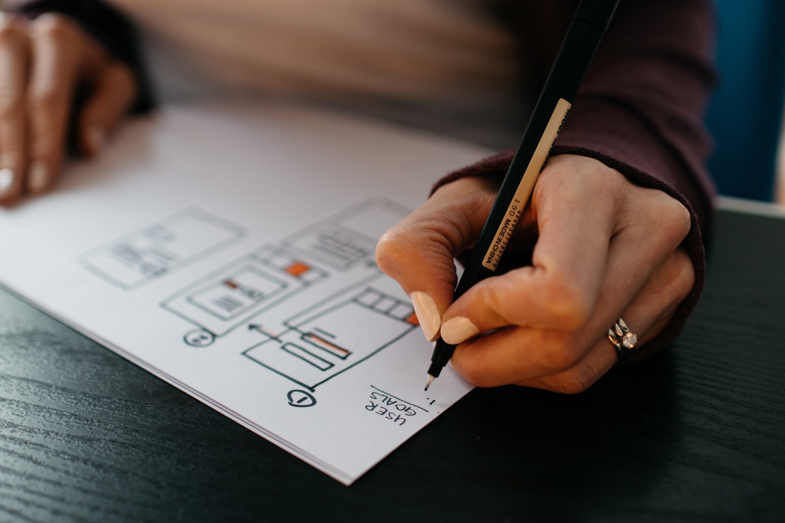 someone designing a website on a paper