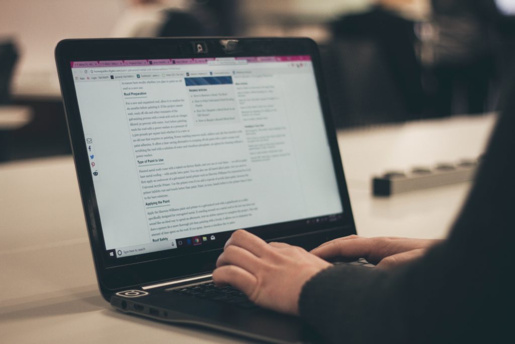 Start by Creating Compelling Blog Content on Your Company’s Website A person writing a blog post on a laptop.