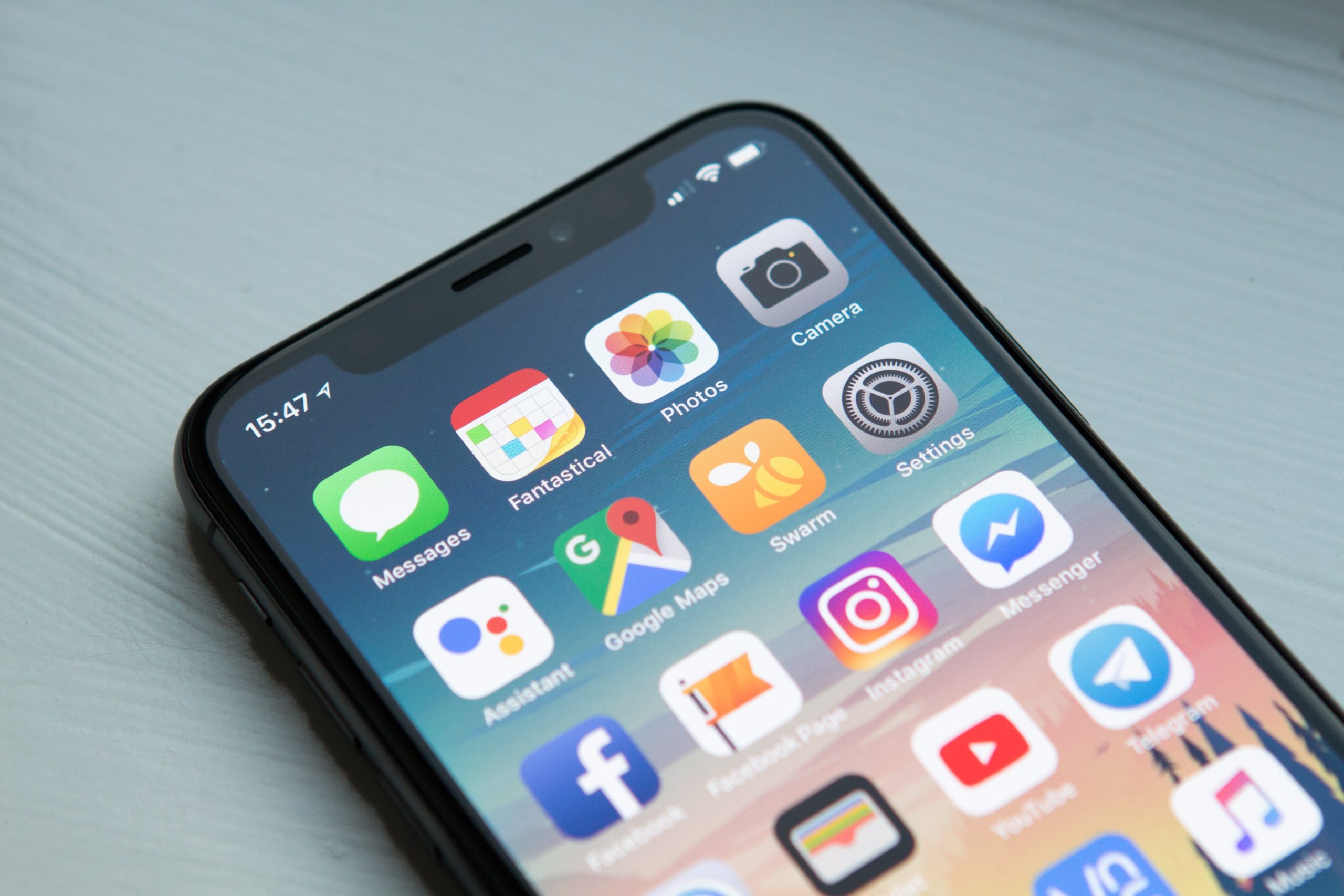 A phone with multiple ios applications displayed. 8 Top Benefits Of IOS Application Development