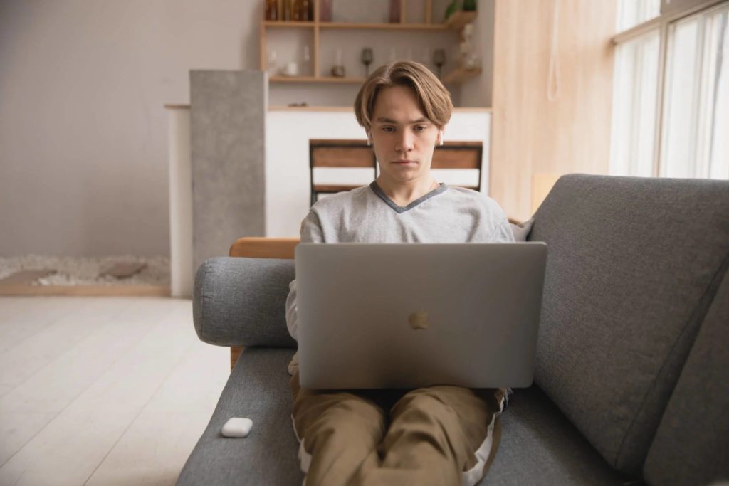 A person using a laptop while lying on a couch and crafting an irresistible brand