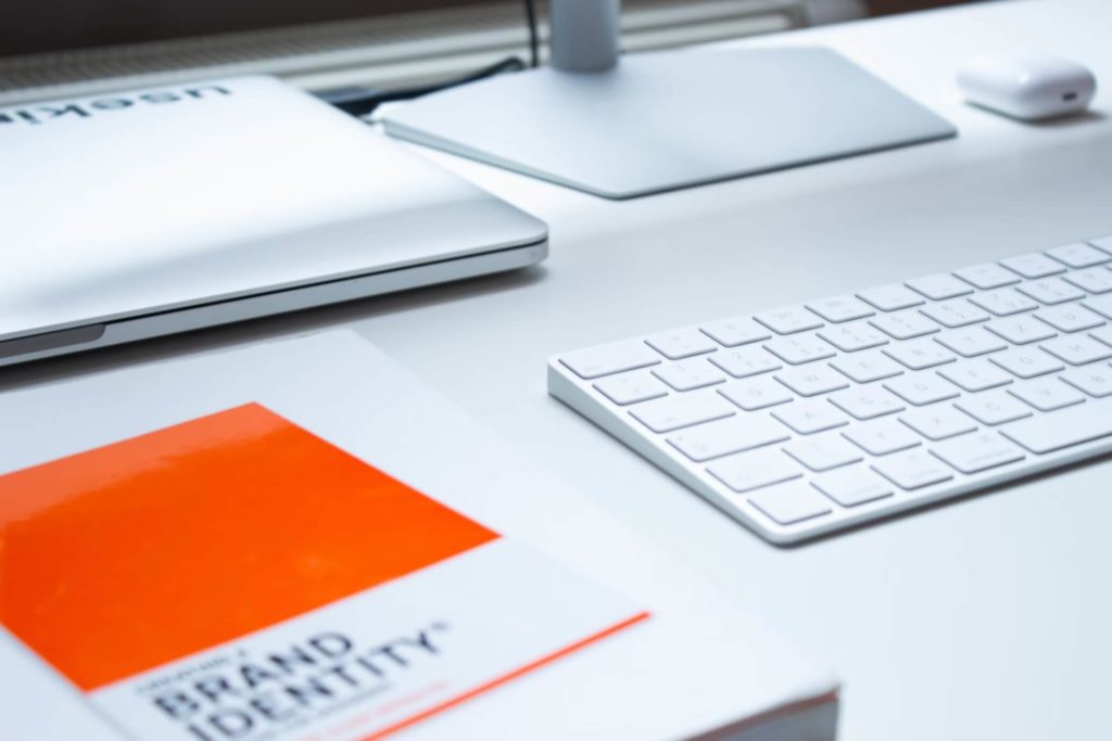 Crafting An Irresistible Brand Strategies for Rehab Center Recognition | Matchbox Design Group | St. Louis, MO A book on brand identity next to a white computer.