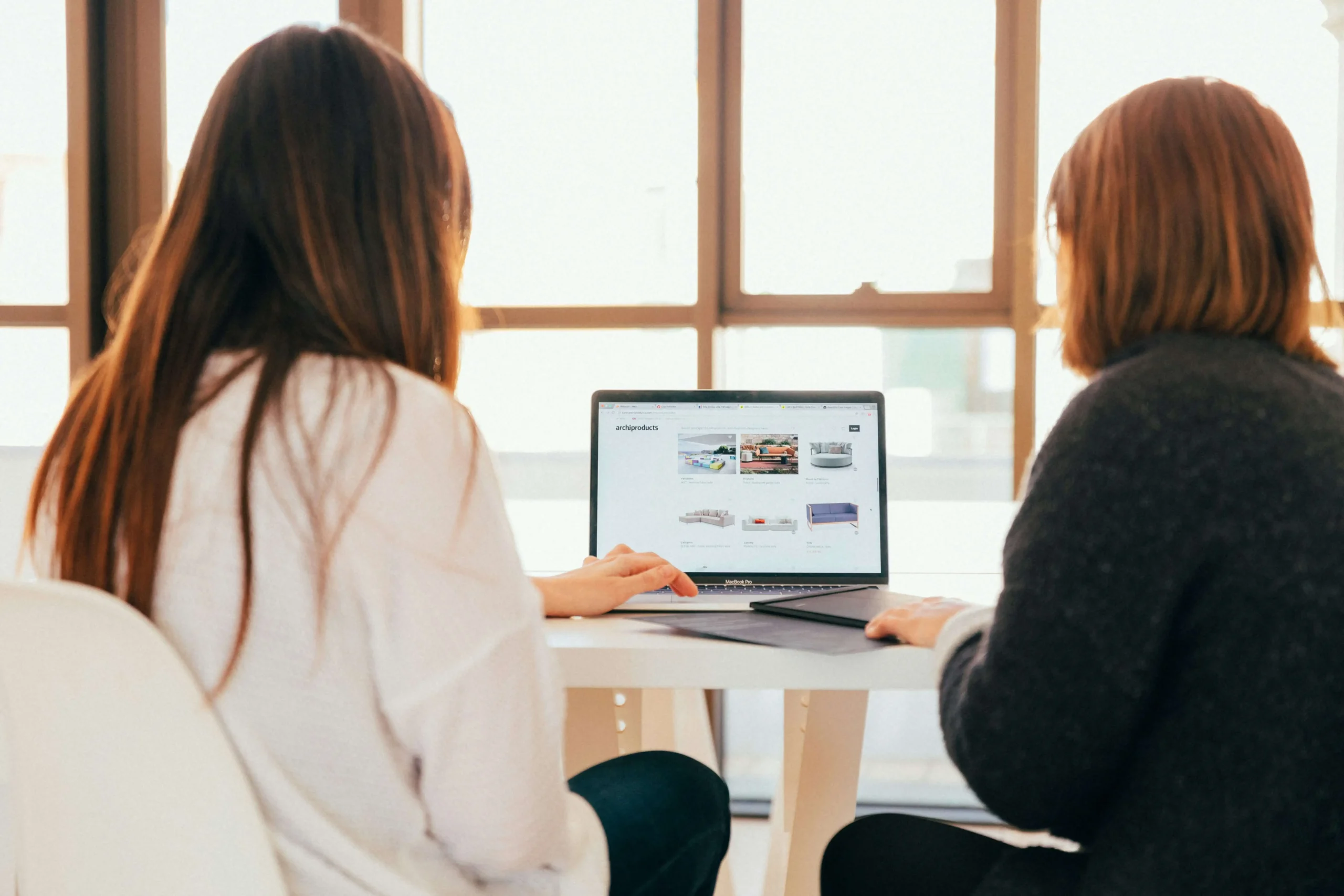 Two women looking at an ecommerce store on a laptop