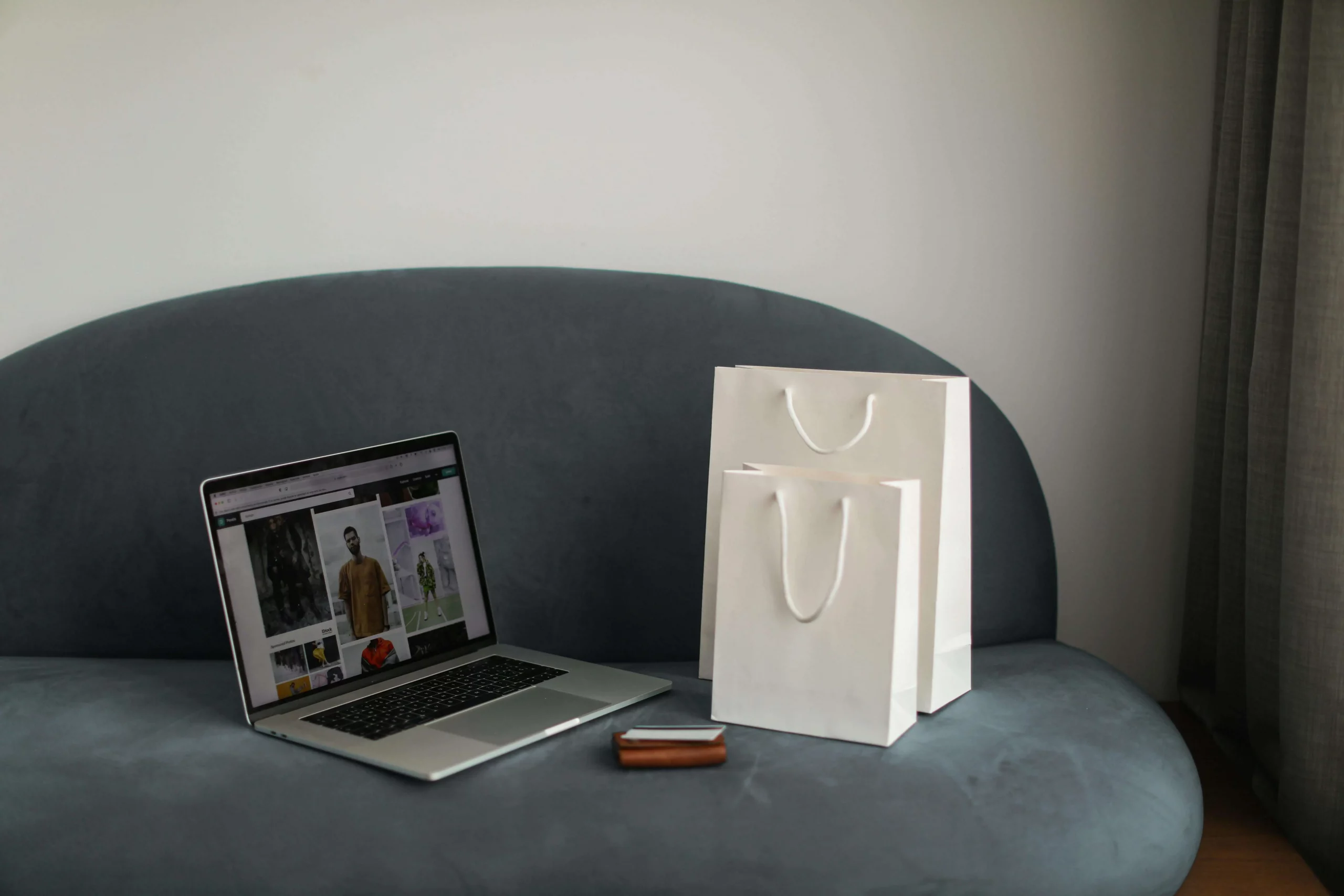 A computer with an ecommerce site open next to a bag.