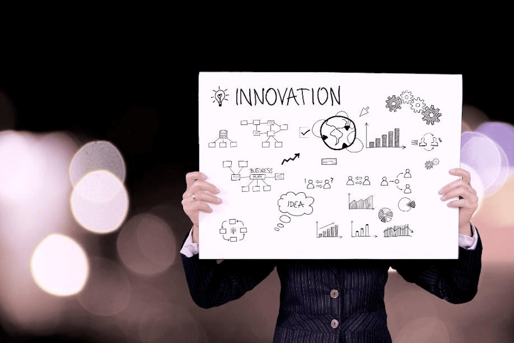 A person holding a sign that says innovation with illustrations on it - Matchbox Design Group A person holding a sign that says innovation with illustrations on