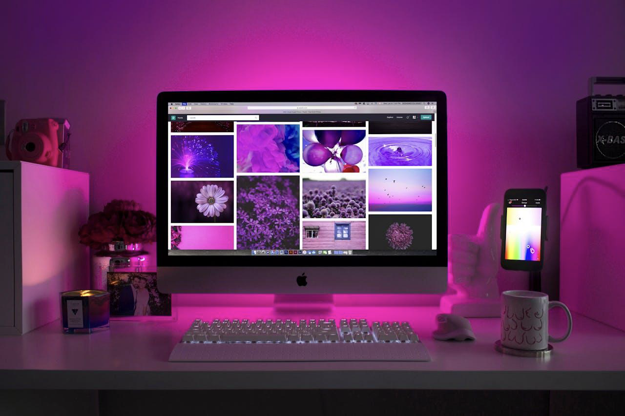 A computer in a pink cubicle with pictures used to align website design with brand identity.