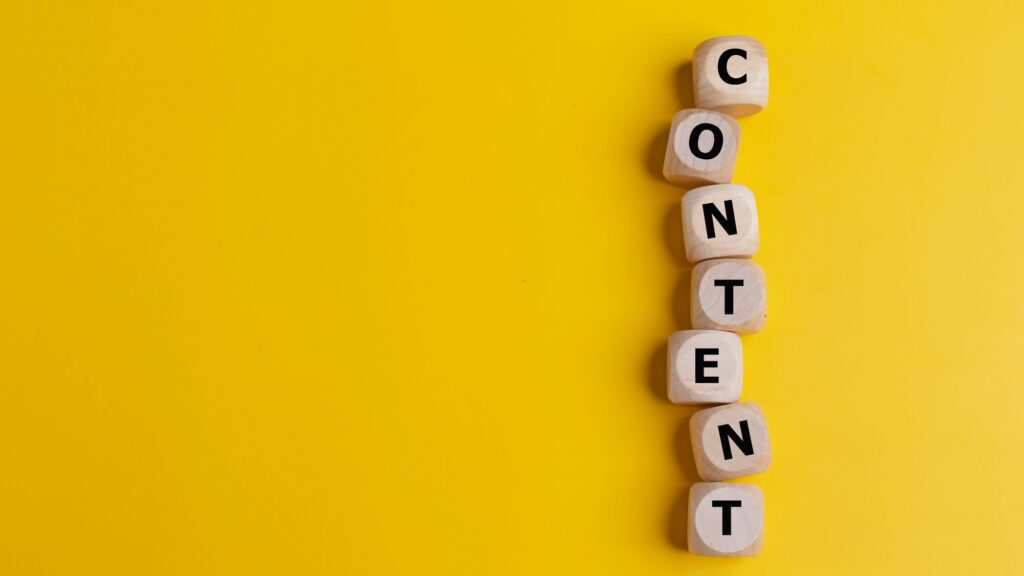 Decide On Content Types | Matchbox Design Group Cubes with the word CONTENT on a yellow background.Content creation. Decide On Content Types.